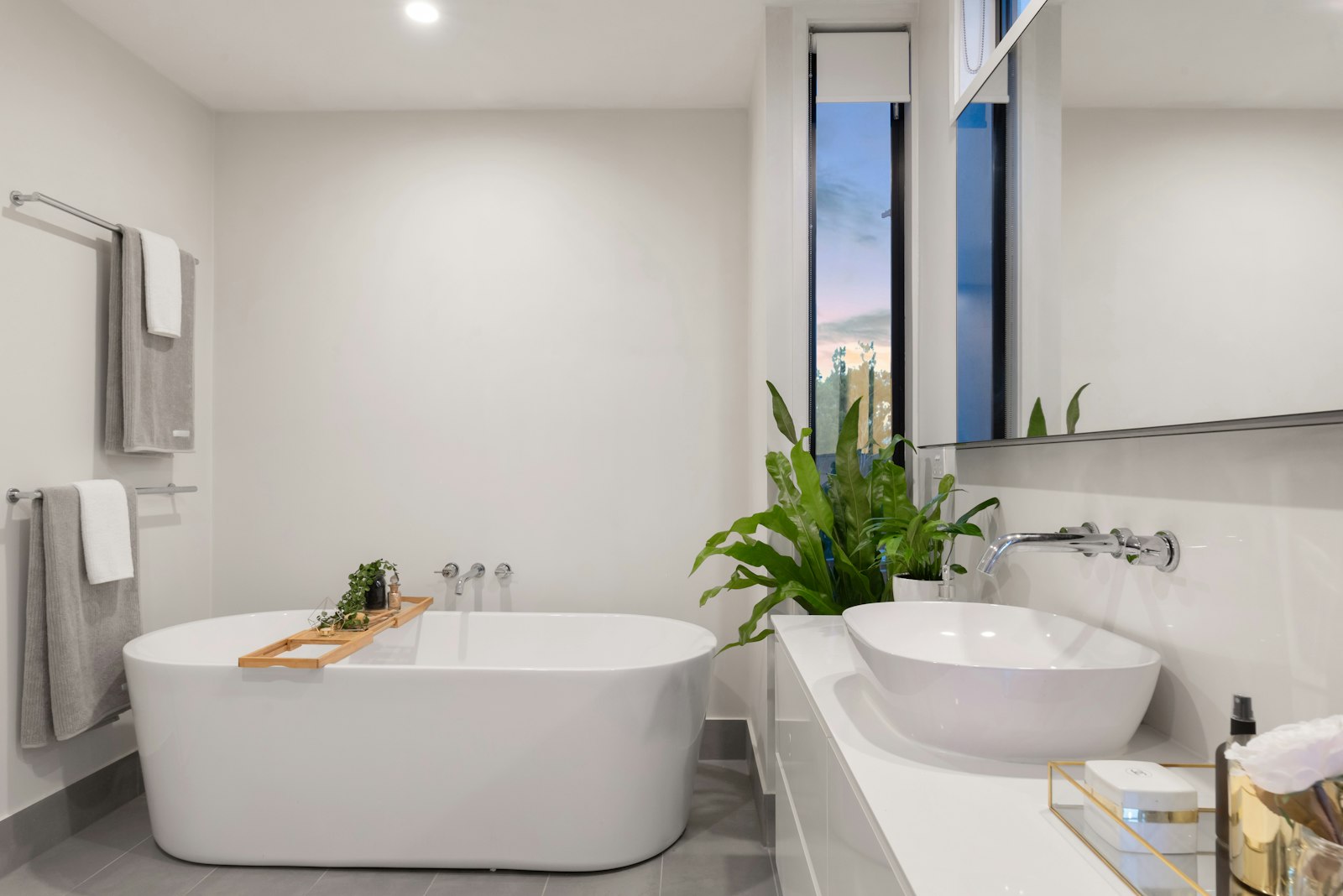 Bathroom with a freestanding tub, tiled surfaces and warm natural finishes